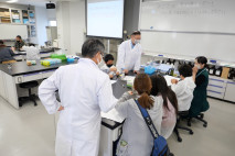 薬学部の実験室にて、衛生化学研究室の長岡寛明先生による講義が行われ、小学生と保護者が水の安全性を確認するための実験を行いました。